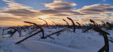 Portekiz, Algarve, Tavira 'daki Praia do Barril plajındaki Anchor Mezarlığı' nın sahilindeki paslı eski çapalar.