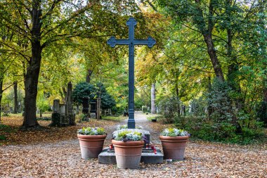 Münih, Almanya - 09 Kasım 2023: Münih 'teki Eski Kuzey Mezarlığı, Almanya' nın tarihi mezar taşlarıyla sonbahar manzarası. Cenazeler 1944 'ten beri burada yapılmadı. Bunun yerine mezarlık bir park olarak kullanılıyor..