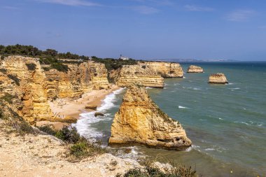 Praia da Marinha Beach among rock islets and cliffs seen from Seven Hanging Valleys Trail, Percurso dos Sete Vales Suspensos. Algarve, Portugal clipart