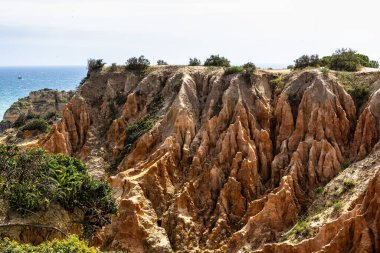 Praia da Marinha Beach among rock islets and cliffs seen from Seven Hanging Valleys Trail, Percurso dos Sete Vales Suspensos. Algarve, Portugal clipart