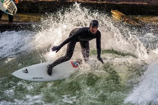 stock image Munich, Germany - December 13, 2023: Winter Surfer in the city river, Munich is famous for people surfing in urban enviroment called Eisbach