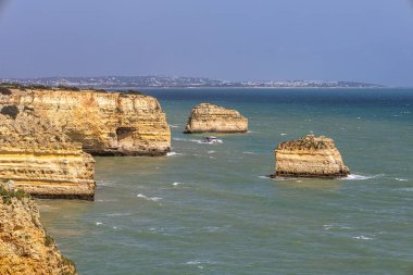 Praia da Marinha Beach among rock islets and cliffs seen from Seven Hanging Valleys Trail, Percurso dos Sete Vales Suspensos. Algarve, Portugal clipart