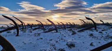 Portekiz, Algarve, Tavira 'daki Praia do Barril plajındaki Anchor Mezarlığı' nın sahilindeki paslı eski çapalar.