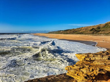 Praia do Norte 'deki deniz fenerinin yanında büyük dalgalar, Portekiz' deki Nazare