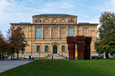 Münih, Almanya - 14 Ekim 2024: Eski Pinakothek Müzesi 'nin ana cephesi Eduardo Chillida' nın soyut heykeli ile binanın önünde Buscando la Luz.