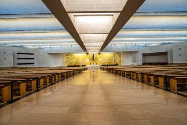 Interior of the modern Minor Basilica of Most Holy Trinity at Fatima, Portugal. View over the altar, aisles and pews. Fatima is a major Marian Shrine for pilgrims clipart