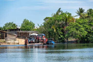 Barreirinhas, Brezilya - 16 Ocak 2025: Rio Preguica, Maranhao, kuzey Brezilya 'daki yağmur ormanlarına doğru kısa bir feribot yolculuğu yapan turistler ve araçlar.