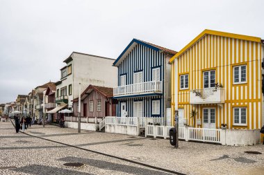 Aveiro, Portekiz - 19 Mar 2025: renkli evleri olan cadde. Çizgili evleri olan cadde, Costa Nova, Aveiro, Portekiz. Kosta Nova, Aveiro, Portekiz 'deki renkli evlerin cepheleri.