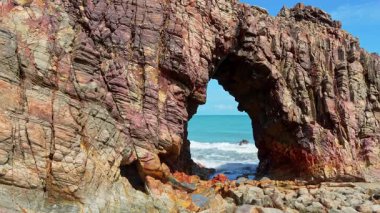 Pedra Furada. Brezilya 'nın Ceara eyaletindeki Jericoacoara plajında ünlü bir turistik eğlence. Delikli taş oluşumu Pedra Furada okyanusun dışında duruyor.
