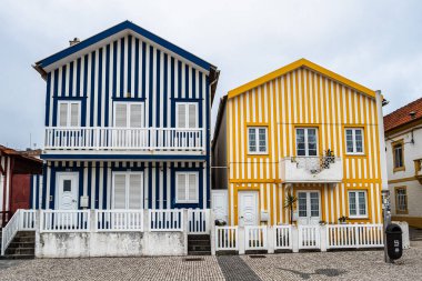 Renkli evleri olan bir sokak. Çizgili evleri olan cadde, Costa Nova, Aveiro, Portekiz. Kosta Nova, Aveiro, Portekiz 'deki renkli evlerin cepheleri.