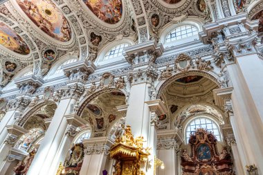 Passau, Almanya - 16 Nisan 2025: Passau, Almanya 'daki St. Stephans katedralinin içi, kulelerin ve ünlü organ borularının tepesinde yeşil metal kubbeleri bulunan eski bir beyaz kilise..