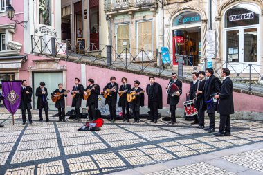 Coimbra, Portekiz - 15 Aralık 2025: Portekiz 'deki Coimbra Üniversitesi öğrencileri şehrin tarihi sokaklarında geleneksel müzik çalıp söylüyorlar