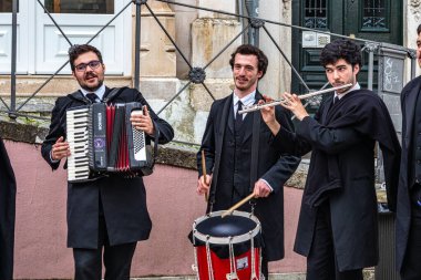 Coimbra, Portekiz - 15 Aralık 2025: Portekiz 'deki Coimbra Üniversitesi öğrencileri şehrin tarihi sokaklarında geleneksel müzik çalıp söylüyorlar