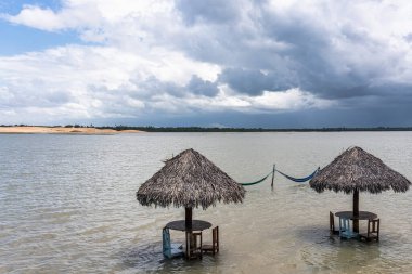 Brezilya 'daki Ceara, Jijoca de Jericoacoara' daki Tatajuba Sahili 'nin güzel Torta Lagünü' nün kıyısında saman kulübeleri.