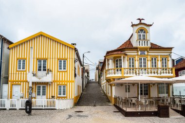 Renkli evleri olan bir sokak. Çizgili evleri olan cadde, Costa Nova, Aveiro, Portekiz. Kosta Nova, Aveiro, Portekiz 'deki renkli evlerin cepheleri.