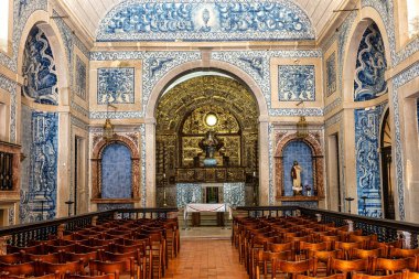 Sesimbra, Portekiz - Mar 01, 2025: Sesimbra, Portekiz 'deki Santa Maria kilisesinin içi. Igreja de Nossa Senhora do Castelo. 17. yüzyıl beyaz binası, kırmızı kapılı, barok tarzı.