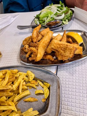 Portekiz 'in Setubal şehrinde ünlü O Rei do choco frito. Kızarmış kalamar ve ahtapot yanında patates kızartması ve salata..