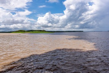 Brezilya 'nın Manaus şehrinde bulunan Suların Buluşması, Rio Negro ile neredeyse siyah renkli bir nehir ve kumlu Amazon Nehri veya Rio Solimoes arasındaki birleşmedir..