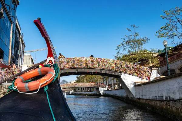Aveiro, Portekiz - 18 Aralık 2025: Portekiz 'in Aveiro kentindeki kanalda geleneksel tekneler. Aveiro 'da renkli Moliceiro tekne gezileri turistler arasında, büyüleyici kanalların keyfini çıkarmak için popülerdir..
