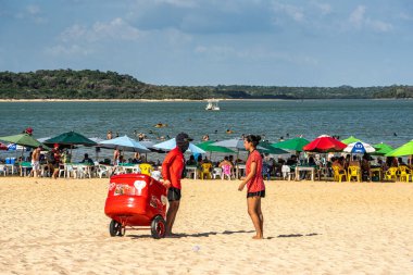 Alter do Chao, Brezilya - 17 Aralık 2024: Şemsiyeler Brezilya 'nın Alter do Chao eyaletinde Tapajos Nehri kıyısındaki Ilha do Amor plajını boyadı.