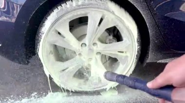 Hamburg, Almanya, 11 Aralık 2022: Audi S3 arabasının alüminyum kenarına özel temizleyici sıkıldı ve yüksek basınçlı temizleyici ile temizlendi