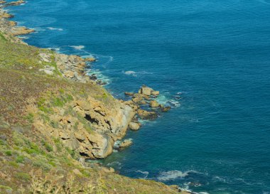 Steep cliffs and turquoise sea at the Cape of Good Hope in South Africa