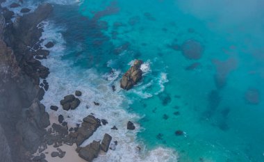 Steep cliffs and turquoise sea at the Cape of Good Hope in South Africa