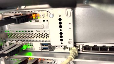 Bir veri merkezinde RJ45 ve fiber optik kablo bağlantıları olan bir sunucu rafında yanıp sönen LED ışıkları