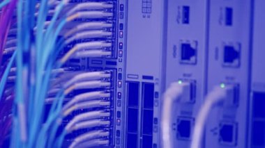 Bir veri merkezinde RJ45 ve fiber optik kablo bağlantıları olan bir sunucu rafında yanıp sönen LED ışıkları