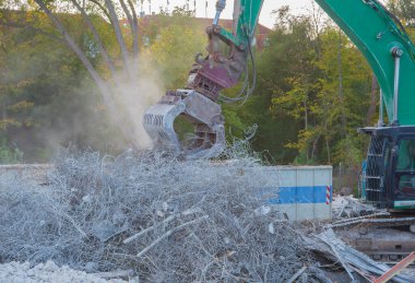 Büyük yıkım kazıcısı bir binayı söküyor.