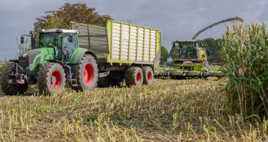 Hamburg, Almanya - 11 Ekim 2023: Claas Jaguar mısır helikopteri ve FENDT Vario traktörü Veenhuis Super Silagewagon ile mısır hasadı sırasında