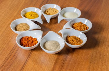 Küçük beyaz kaselerde çeşitli baharatlar.