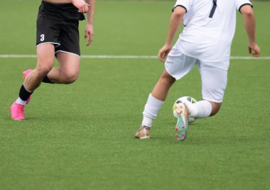 Futbol oynarken yapay bir sahada futbol oynayan futbolcu.