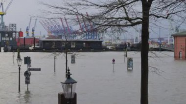 Hamburg, Almanya - 22 Aralık 2023: Elbe sel ve fırtına dalgaları St. Pauli balık pazarında, arka planda Hamburg Konteynır Terminali Burchardkai