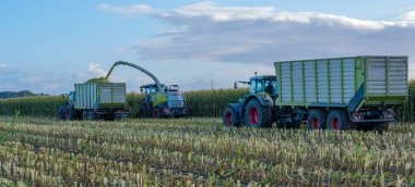 Hamburg, Almanya - 11 Ekim 2023: Silagewagon ve Claas Jaguar mısır hasadı sırasında FENDT Vario traktörü