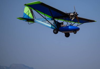 Mavi yeşil Ultralight uçağı ya da Microlight uçağı Hoedspruit Güney Afrika pistinden kalkıyor.