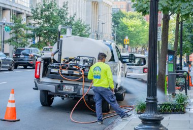 Washington, D.C., ABD - 01 Mart 2025: Bahçıvan çalışanı Washington, D.C. sokaklarındaki santralleri sular 
