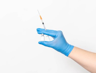 Doktor elinde aşı tutarken bir aşı ve tek kullanımlık şırınga taşıyor.