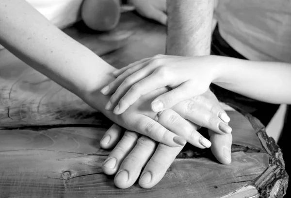 Black and white photo of mom, dad and daughter\'s hands on each other, close-up. Team game concept