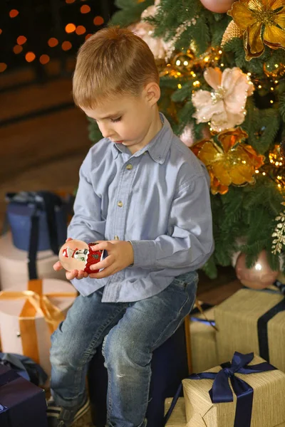 Sevimli çocuk elinde Noel Baba 'yla balona bakıyor. Mavi gömlekli ve kot pantolonlu, yeni yıl arifesi. Peri masalı ve tatil konsepti