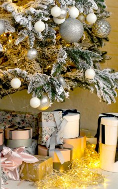 Noel ağacının altında ışıklı hediyeler. Evde şenlik var. Yeni yıl ve Noel konsepti