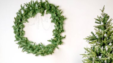 Beyaz bir duvarda köknar dalları olan bir pankart. Yeni yıl ve Noel konsepti