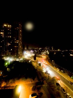 Yüksek bir noktadan gece büyük bir şehir. Farlarla hareket eden arabalar, karanlıkta şehrin ışıkları. Kentsel yaşam tarzı