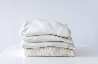 Katlanmış renkli giysiler yığını. Ev gardırobunda kompakt depolama.