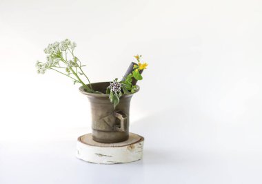 Medicinal herbs. Bright summer flowers in brass mortar. Yarrow plant