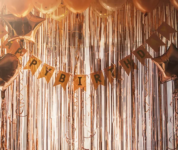 Birthday party decor. Foil curtains and bauble. Cozy home interior decoration for celebration.