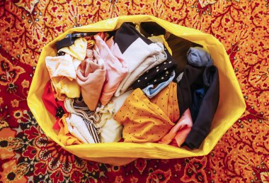 Hayır işi ya da geri dönüşüm için kullanılmış giysilerle dolu plastik torba.