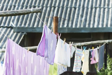 İpte asılı renkli pamuklu çamaşırlar. Arka bahçede tekstil kurutma.