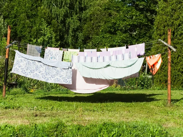 stock image Washed colorful cotton laundry hanging on the rope. Textile drying on backyard.