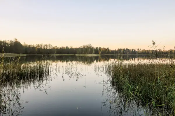 Peaceful landscape with lake in autumn sunset light in Latvia.